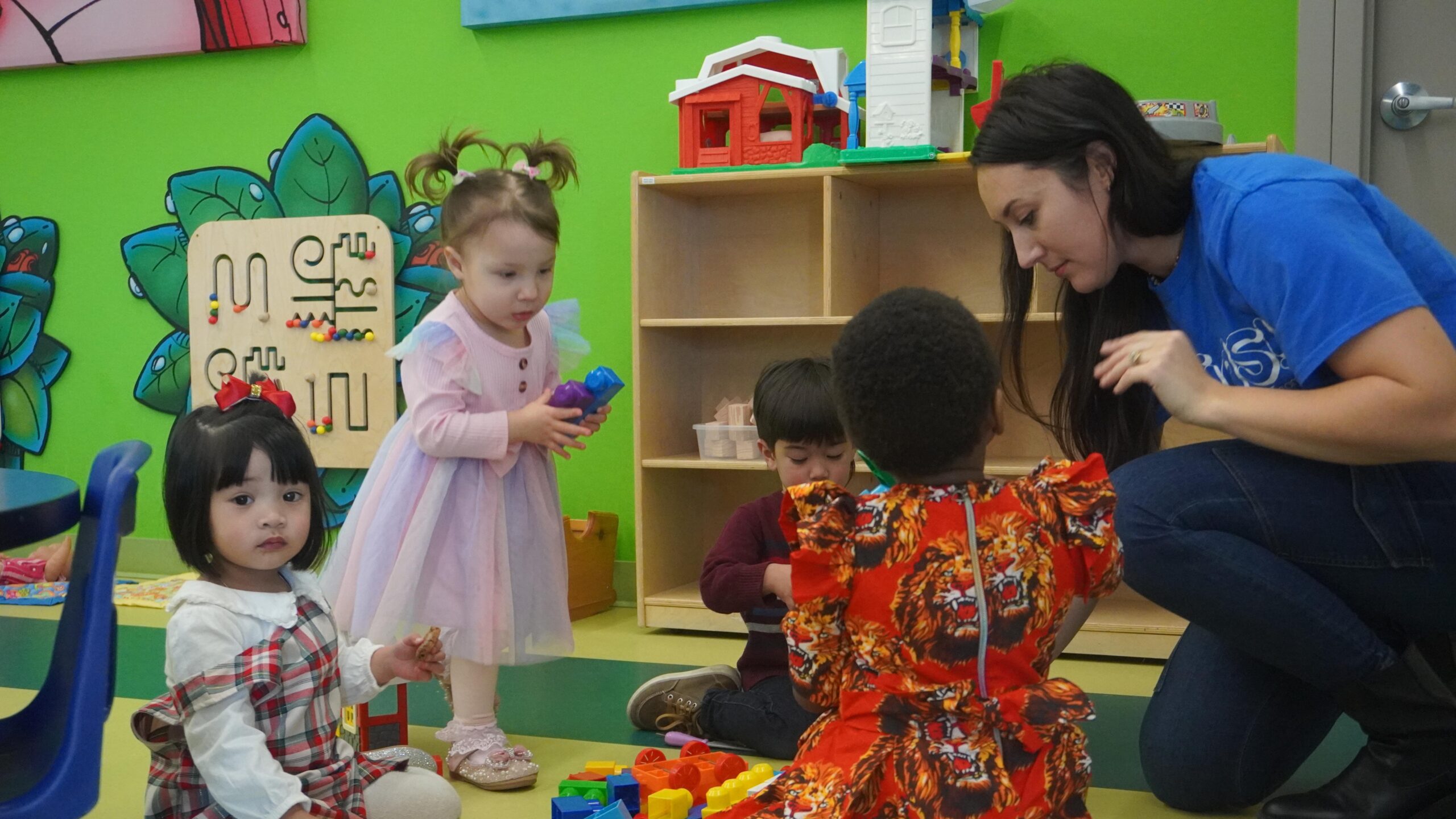 girl's left hand wrap around toddler while reading book during golden hour