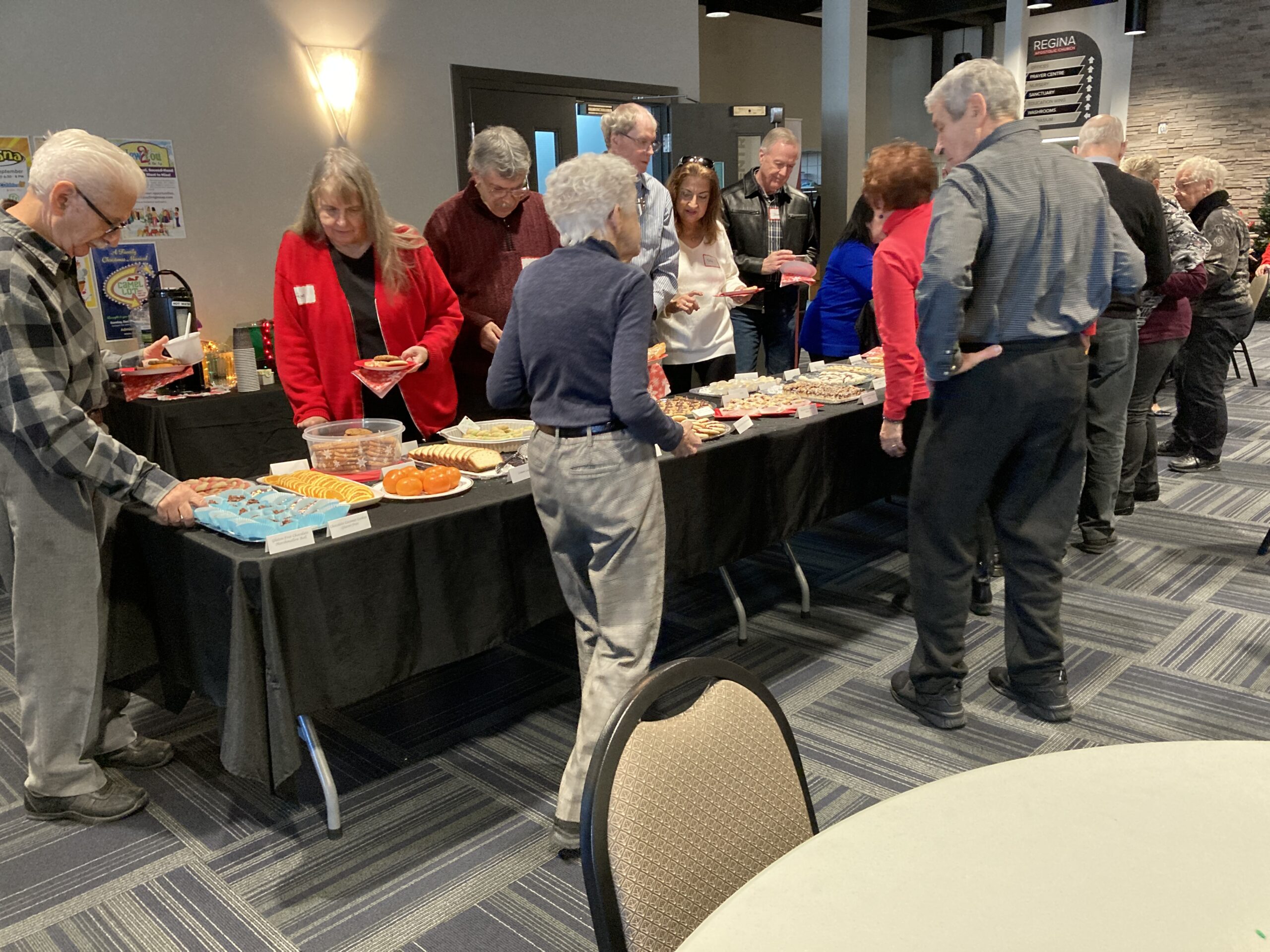 A group of people standing around a buffet line