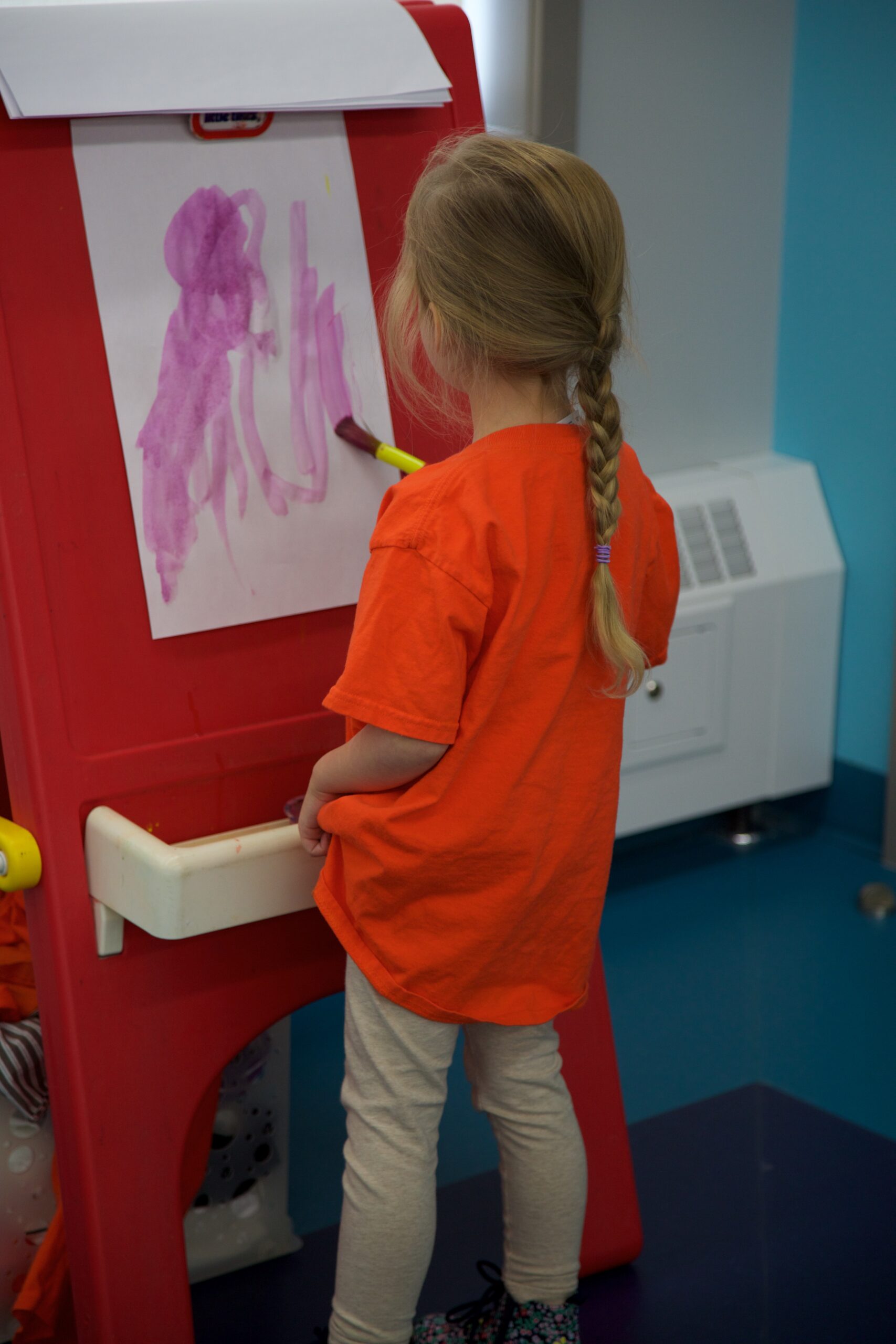 people sitting on chair in front of table while holding pens during daytime